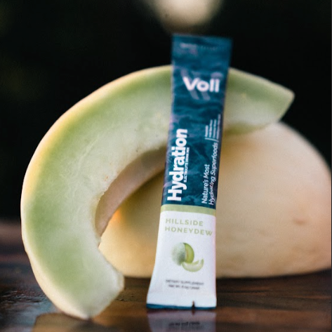 Voll Hydration package with a cantaloupe on a reflective surface